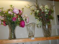 Three glass vases and a quantity of faux flowers and branches.