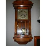 An Edwardian oak cased spring wind wall clock, in working order. COLLECT ONLY.