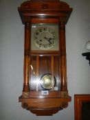 An Edwardian oak cased spring wind wall clock, in working order. COLLECT ONLY.