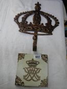 A metal hook in the form of a crown and a Danish armorial tile.