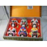 A boxed set of six painted masks