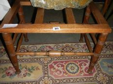 An arts & crafts early 20th-century luggage/suitcase stand in oak, makers label underneath. COLLECT