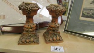 A pair of fruit decorated candlesticks.