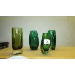 A pair of green glass vases and two other green glass items.