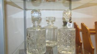 Three cut glass decanters.