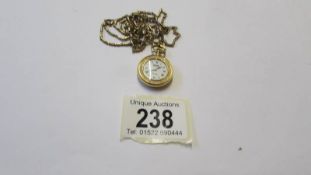 A gilded pendant watch with enamel style back and front, Swiss made, Bernex. In working order.