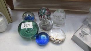 Seven glass paperweights.