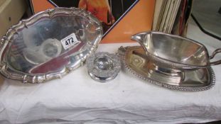 A silver plate gravy boat on tray, another tray and a tea strainer.