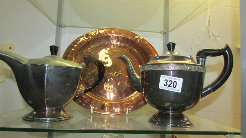 A brass tray and two plated teapots.