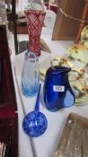 Two blue studio glass vases, a red vase and one other item.