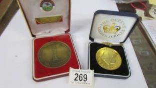 A football medallion and a Queen Elizabeth II Golden Jubilee medallion.