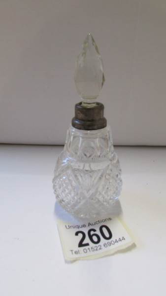 A glass perfume bottle with silver collar and original stopper.