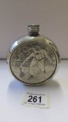 A silver plate hip flask depicting a tennis player.