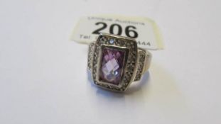 A silver ring with amethyst coloured stone, size R.