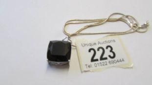 A silver pendant set square black onyx.