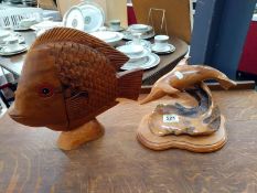 A carved wood dolphin and another carved fish