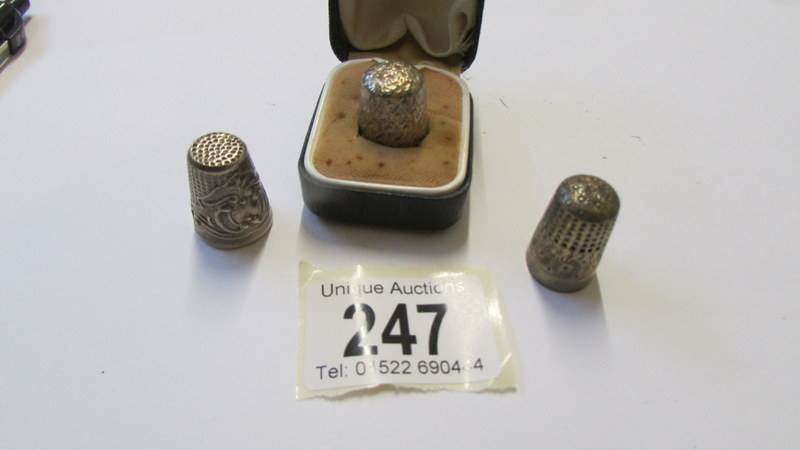 Three silver thimbles including one in case,.