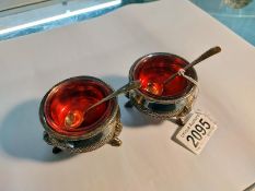 A pair of silver plate salts with Cranberry glass liners and two silver salt spoons