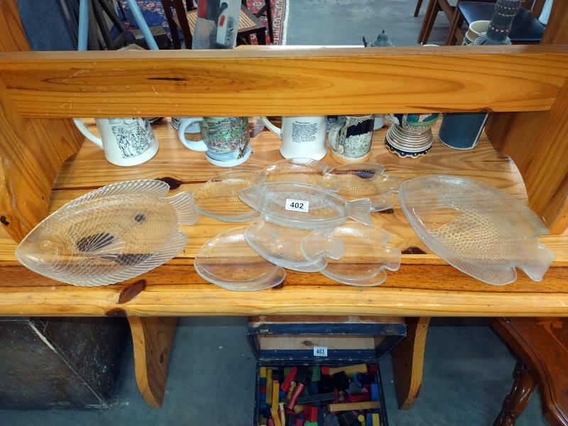 A quantity of glass fish shape plates including one plastic. COLLECT ONLY.