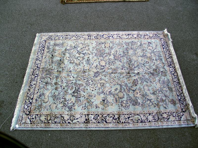 A light blue floral/ nature patterned rug. Length 245cm x 170cm. COLLECT ONLY.