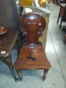 A Victorian mahogany hall chair. Split in the wood across the back of the seat.