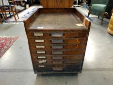 A seven drawer printers cabinet set on brass wheels. 56cm x 45cm x 57cm.