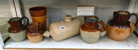 Four stoneware jugs including Doulton Lambeth, foot warmer and vase. COLLECT ONLY.