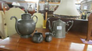A pewter James Dixon Royles patent self pouring teapot, another teapot, a milk jug and a sugar bowl.