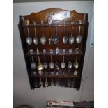 A selection of tourist collectors spoons on rack