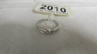 An 18ct white gold ring with central diamond and diamond shoulders, size N, 3.3 grams.