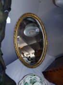 An oval gilt framed bevel edge mirror. 39 cm x 62cm. COLLECT ONLY.