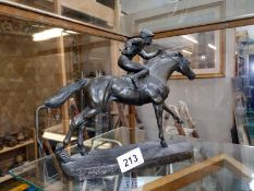 A bronzed resin figure of a Jockey on a racehorse, COLLECT ONLY.