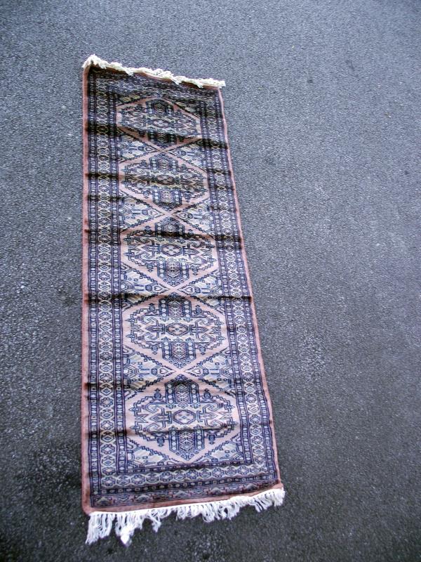 A Middle Eastern style patterned rug. Length 183 cm x 62cm. COLLECT ONLY.