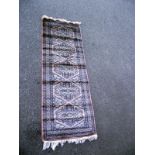 A Middle Eastern style patterned rug. Length 183 cm x 62cm. COLLECT ONLY.