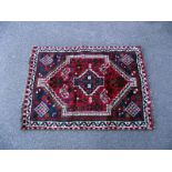 A small red/blue Persian style rug. Length 140cm x 97cm. COLLECT ONLY.