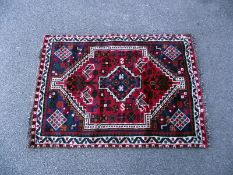 A small red/blue Persian style rug. Length 140cm x 97cm. COLLECT ONLY.