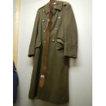 A WW2 military overcoat with officer's gilt REME buttons and two leather belts.