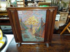 A mahogany fire screen with glazed woolwork of sailing boats in the sunset. 57cm x 58cm