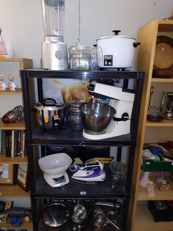 Four shelves of kitchen ware including slow cooker, blenders etc