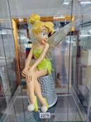 A large figure of Tinkerbell on a thimble
