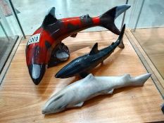 Two ceramic sharks and a stone shark