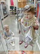 A Bisque porcelain figure of a small girl seated and another figure, 'Papa's Darling'.