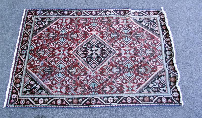 A red Middle Eastern style patterned rug. Length 200cm x 130cm. COLLECT ONLY.