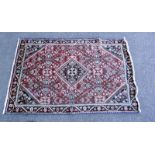 A red Middle Eastern style patterned rug. Length 200cm x 130cm. COLLECT ONLY.
