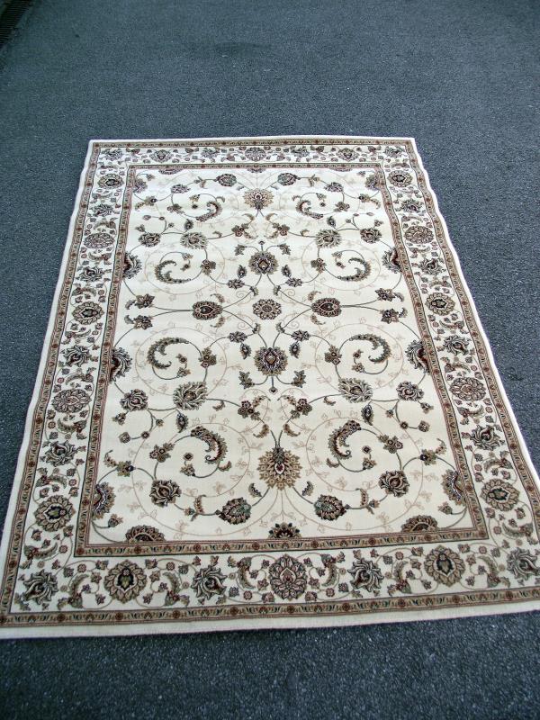 A large beige patterned/ Persian rug. Length 2.28cm x 1.60cm. COLLECT ONLY.