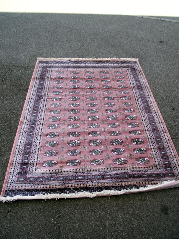 A pink patterned Persian style rug. Length 240cm x 170cm. COLLECT ONLY.