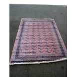 A pink patterned Persian style rug. Length 240cm x 170cm. COLLECT ONLY.
