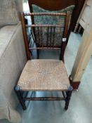 A 19/20th Century oak stick back chair with rush seat. COLLECT ONLY