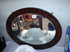 AN oval bevel edge mirror. 60cm x 50cm. COLLECT ONLY.