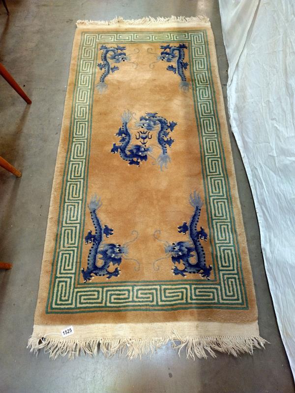 A beige and green rug with Blue dragon motifs. 172 cm x 78cm